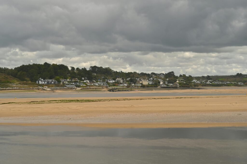 Charming Cornish coastal view with sandbanks, estuary, and overcast sky.